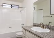 Thumbnail 44 of 53 - A bathroom with a granite countertop and a white sink.