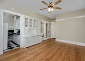 Thumbnail 9 of 18 - an empty living room and kitchen with wood floors and a ceiling fan