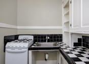 Thumbnail 11 of 18 - a kitchen with black and white checkered floor and a stove and sink