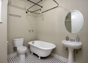 Thumbnail 14 of 18 - a white bathroom with a sink toilet and bath tub