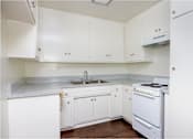Thumbnail 28 of 28 - a kitchen with white cabinets and white appliances and a sink
