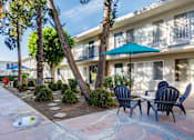 Thumbnail 5 of 28 - a patio with chairs and umbrellas in front of a building
