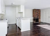 Thumbnail 21 of 28 - an empty kitchen with white cabinets and a fireplace
