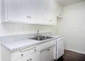 Thumbnail 22 of 28 - an empty kitchen with white cabinets and a sink