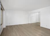 Thumbnail 21 of 41 - an empty living room with white walls and wood flooring