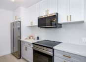 Thumbnail 25 of 41 - a kitchen with white cabinets and a stainless steel refrigerator
