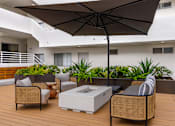 Thumbnail 35 of 63 - A patio with a table, chairs, and an umbrella.