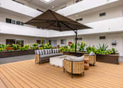 Thumbnail 40 of 63 - A patio with a couch and umbrella.