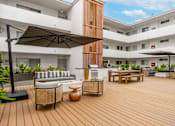 Thumbnail 42 of 63 - A patio with a black umbrella and wooden furniture.