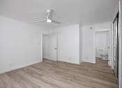 Thumbnail 52 of 63 - A room with a ceiling fan and wooden flooring.