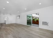 Thumbnail 61 of 63 - A room with a wooden floor and a glass door leading to a balcony.