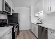 Thumbnail 63 of 63 - A modern kitchen with white cabinets and stainless steel appliances.