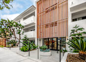 Thumbnail 5 of 63 - A modern building with a white and orange facade and a landscaped courtyard.