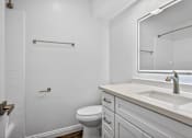 Thumbnail 8 of 52 - A white bathroom with a toilet, sink, and mirror.