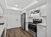 Thumbnail 10 of 52 - A modern kitchen with white cabinets and stainless steel appliances.