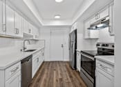 Thumbnail 11 of 52 - A kitchen with white cabinets and black appliances.