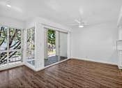 Thumbnail 12 of 52 - A room with a sliding glass door leading to a balcony.