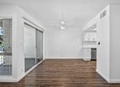 Thumbnail 14 of 52 - A spacious room with a ceiling fan and a sliding glass door leading to a balcony.