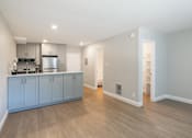 Thumbnail 18 of 45 - a kitchen and living room with blue cabinets and a wood floor