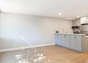 Thumbnail 19 of 45 - an empty kitchen with blue cabinets and a wood floor
