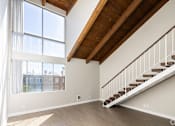 Thumbnail 14 of 45 - a living room with a staircase and large windows