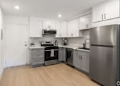 Thumbnail 11 of 45 - a renovated kitchen with stainless steel appliances and white cabinets