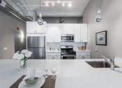 Thumbnail 1 of 17 - a white kitchen with stainless steel appliances and white counter tops