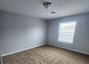 Thumbnail 18 of 29 - A room with a carpeted floor and a window.