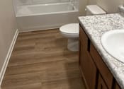 Thumbnail 5 of 6 - A white toilet sits next to a sink in a bathroom.