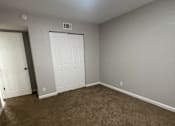 Thumbnail 23 of 29 - A room with a carpeted floor and two doors.