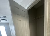 Thumbnail 21 of 29 - A white door is in a hallway with wood flooring.