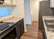 Thumbnail 12 of 20 - a kitchen with granite counter tops and stainless steel appliances and a stainless steel refrigerator