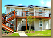 Thumbnail 8 of 10 - A house with a staircase leading to a deck.
