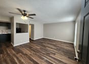 Thumbnail 12 of 29 - A room with a ceiling fan and wooden flooring.
