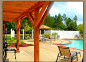 Thumbnail 10 of 10 - A pool area with a wooden pergola and chairs.