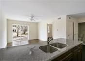 Thumbnail 3 of 4 - A kitchen with a sink and a ceiling fan.