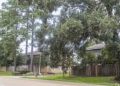 Thumbnail 19 of 20 - a house with a fence and trees in front of it