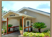 Thumbnail 1 of 10 - A small building with a porch and a sign that says "OFFICE".