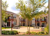 Thumbnail 5 of 10 - Apartment complex with a tree in front.