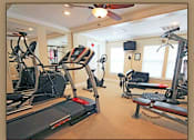 Thumbnail 4 of 10 - A gym with treadmills, elliptical machines and weights.
