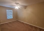 Thumbnail 14 of 20 - A room with a ceiling fan and a window with blinds.