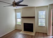 Thumbnail 11 of 20 - a living room with a fireplace and a ceiling fan