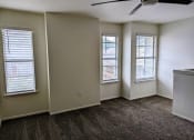 Thumbnail 15 of 20 - an empty living room with three windows and a ceiling fan