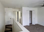 Thumbnail 14 of 20 - a living room with white walls and white doors and a ceiling fan