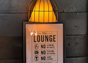 Thumbnail 9 of 24 - A sign for the lounge with a light hanging above it.