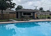 Thumbnail 3 of 24 - A pool with a red brick border and a house in the background.