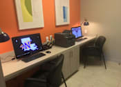 Thumbnail 11 of 20 - A workspace with a laptop, a desktop computer, and a printer on a white desk.