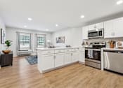 Thumbnail 1 of 18 - A modern kitchen with white cabinets and stainless steel appliances at Roosevelt Commons Apartments, Pennsylvania