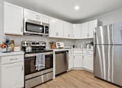 Thumbnail 2 of 18 - A kitchen with white cabinets and stainless steel appliances at Roosevelt Commons Apartments, Philadelphia, 19152