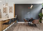 Thumbnail 40 of 57 - A modern dining room with a black table and chairs.